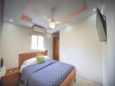 a bedroom with a bed and a flat screen tv at CC 3 Casa de Compai Unit 3 Steps to Everything in Sosúa