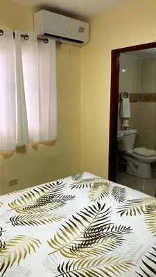 a bedroom with a bed with a black and white comforter at Comfortable Apartament 20 Minutes from the airport in San Isidro
