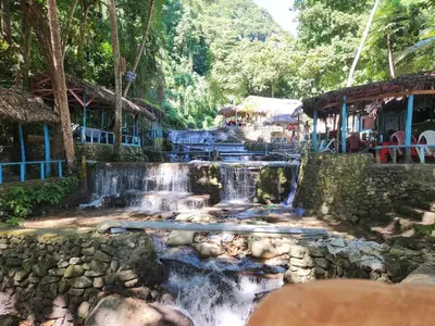 a waterfall in the middle of a forest with houses at 2 Bdrm, 1 Bath, Wifi, Near River and Beach,4L in Paraíso