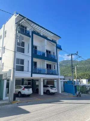 a white building with cars parked in front of it at 2 Bdrm, 1 Bath, Wifi, Near River and Beach, 2L in Paraíso