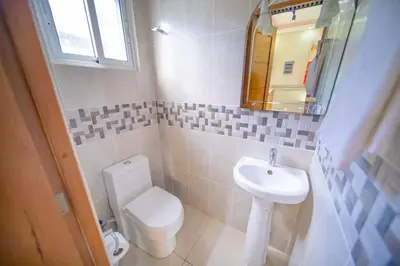 a bathroom with a toilet and a sink and a mirror at Stylish 1BR in Sosua Walkable & Pool Fast WIFi in Sosúa