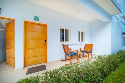 a porch with two chairs and a wooden door at Stylish 1BR in Sosua Walkable & Pool Fast WIFi in Sosúa