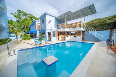 a swimming pool with blue water in front of a house at 1BR Apt with Pool & Cigar Bar Lounge Casa de Compai in Sosúa