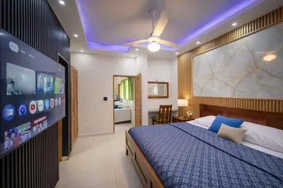 a bedroom with a large bed and a flat screen tv at 1BR Apt with Pool & Cigar Bar Lounge Casa de Compai in Sosúa