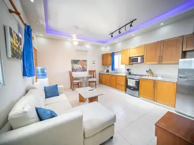 a living room with a white couch and a kitchen at CC 7 Casa de Compai Unit 7 AC WiFi Prime Location in Sosúa