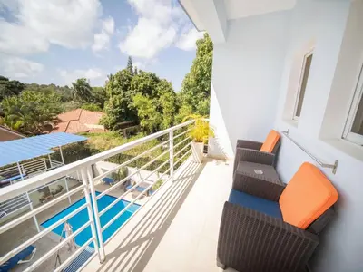 a balcony with chairs and a swimming pool at CC 8 Casa de Compai Unit 8 AC WiFi & Full Kitchen in Sosúa