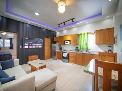 a living room with a couch and a kitchen at CC 8 Casa de Compai Unit 8 AC WiFi & Full Kitchen in Sosúa