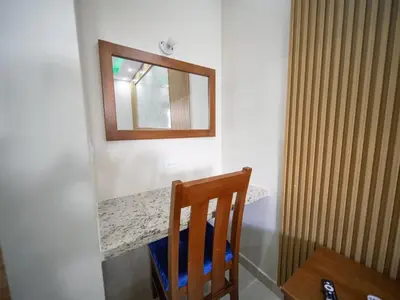 a table with a chair and a mirror on a wall at Casa de Compai Unit 9 AC WiFi Prime Location in Sosúa
