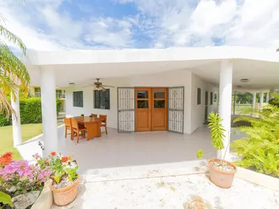a white house with a porch with a dining room at 2 Bedroom Villa with private Pool in Sosua in Sosúa