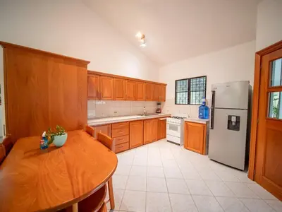 a kitchen with a wooden table and a refrigerator at 2 Bedroom Villa with private Pool in Sosua in Sosúa