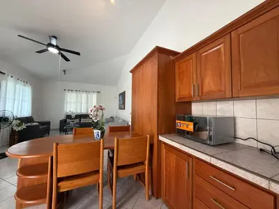 a kitchen with wooden cabinets and a table with chairs at 2 Bedroom Villa with private Pool in Sosua in Sosúa