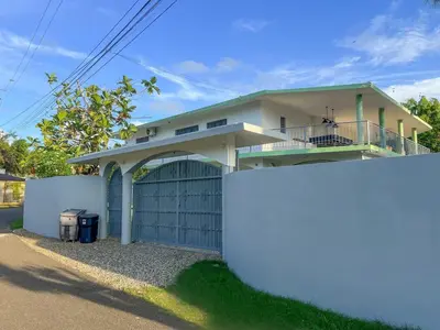 a house with a gate and a garage at 14 Bedroom Villa 2 mins from Sosua in Sosúa