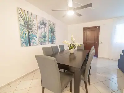 a dining room with a table and chairs and a painting at 14 Bedroom Villa 2 mins from Sosua in Sosúa