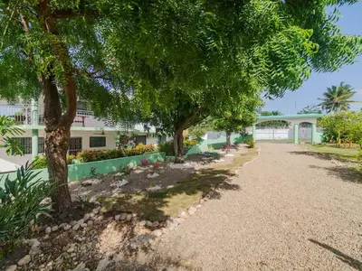 a walkway in front of a building with trees at 14 Bedroom Villa 2 mins from Sosua in Sosúa