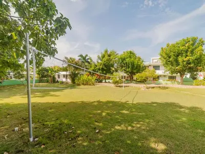 a net in a field with trees and a building at 14 Bedroom Villa 2 mins from Sosua in Sosúa