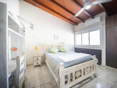 a bedroom with a wooden bed and a window at HUGE Balcony APT next to HARD ROCK CAFE and Beach in Sosúa