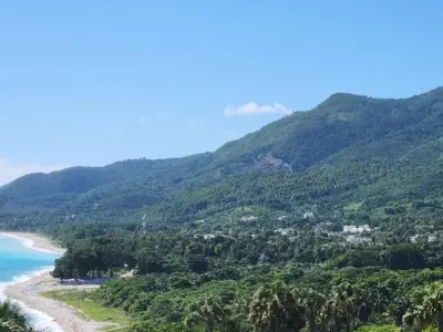 a view of a beach with trees and mountains at 2 Bdrm 1 Bath Near River and Beach, 3L, Paraíso, Barahona in Paraíso