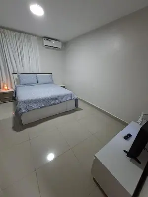 a white bedroom with a bed and a desk at Apartment in Santo Domingo in El Caliche