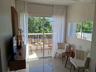 a living room with a sliding glass door with a table and chairs at Apartment in Santo Domingo in El Caliche