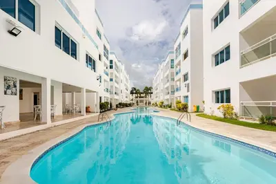 a swimming pool in the courtyard of a apartment building at Large apartment at the foot of the beach in Punta Cana