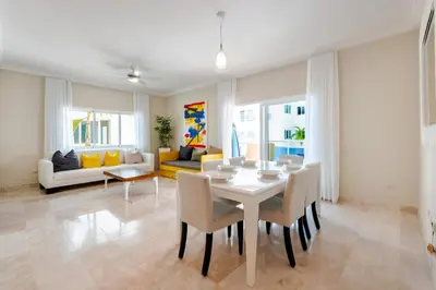a living room with a white table and chairs at Large apartment at the foot of the beach in Punta Cana
