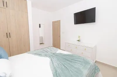 a bedroom with a bed and a tv on a wall at Stylish 2BR Apartment in the Heart of Bayahibe in San Rafael del Yuma