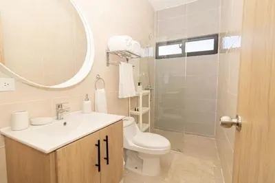 a bathroom with a sink and a toilet and a mirror at Stylish 2BR Apartment in the Heart of Bayahibe in San Rafael del Yuma