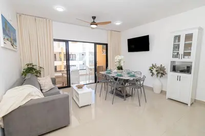 a living room with a gray couch and a table at Stylish 2BR Apartment in the Heart of Bayahibe in San Rafael del Yuma