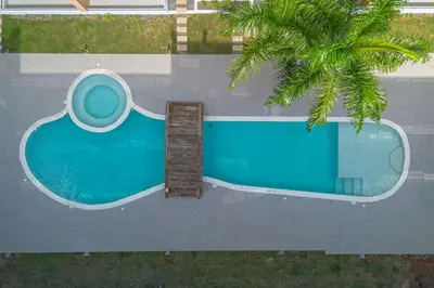 an overhead view of a swimming pool with a palm tree at Stylish 2BR Apartment in the Heart of Bayahibe in San Rafael del Yuma