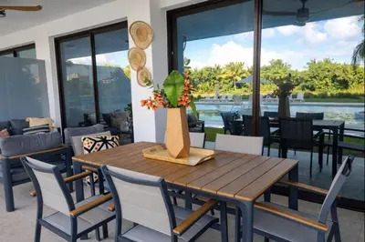 a dining room with a wooden table and chairs at Aqua Poolside Serenity Pool & Golf 2B Cana Bay in Punta Cana