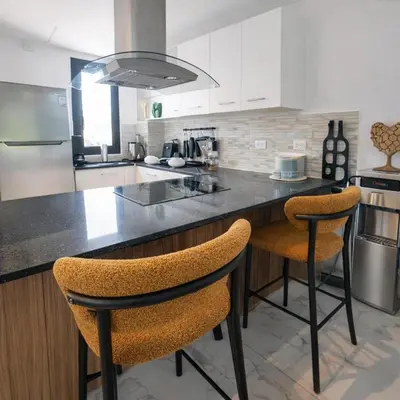 a kitchen with a counter and two bar stools at Aqua Poolside Serenity Pool & Golf 2B Cana Bay in Punta Cana