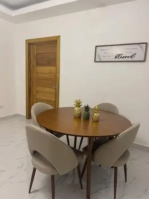 a dining room table with chairs and a wooden table at Los Corales del Sur- Entire rental unit in Santo Domingo Este, Dominican Republic in Ensanche Savica de Mendoza