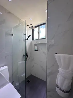 a bathroom with a glass shower and a toilet at Los Corales del Sur- Entire rental unit in Santo Domingo Este, Dominican Republic in Ensanche Savica de Mendoza