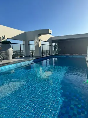 a swimming pool with blue water in a building at Los Corales del Sur- Entire rental unit in Santo Domingo Este, Dominican Republic in Ensanche Savica de Mendoza