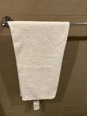 a white towel hanging on a towel rack in a bathroom at Torre armonía in Punta