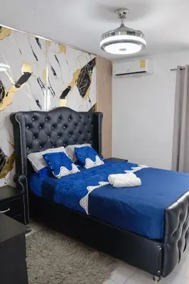 a bedroom with a blue bed with a blue comforter at Spacious 3BR Duplex with Private Rooftop , Ideal for Monthly & Corporate Stays in San Isidro