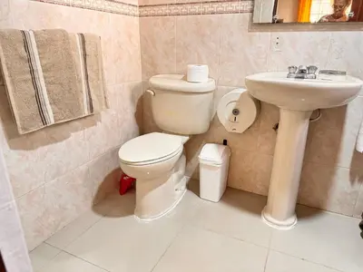 a bathroom with a toilet and a sink at Cozy Huge and Lovely 3 bedrooms apts 2bathdrooms in La Estrella