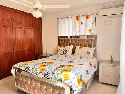 a bedroom with a bed with a floral comforter at Cozy Huge and Lovely 3 bedrooms apts 2bathdrooms in La Estrella