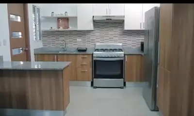 a kitchen with white cabinets and a stove top oven at Mediterraneo in Canabacoa