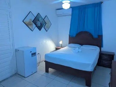 a bedroom with a bed with a blue light at Casa Gadlu Hotel in Santo Domingo