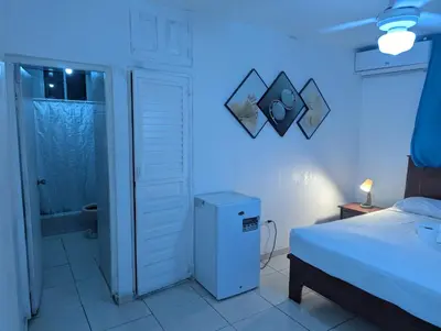 a bedroom with a bed and a blue light at Casa Gadlu Hotel in Santo Domingo