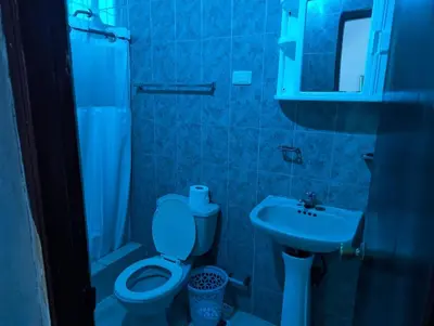 a blue bathroom with a toilet and a sink at Casa Gadlu Hotel in Santo Domingo