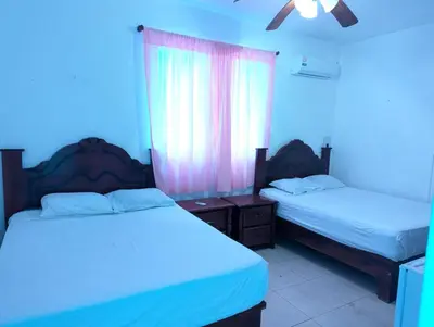 two beds in a room with blue lights at Casa Gadlu Hotel in Santo Domingo