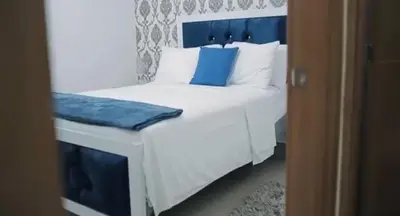 a bedroom with a white bed with blue pillows at Airbnba304 in Canabacoa