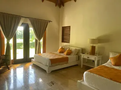 a bedroom with two beds and a large window at Residence in Juan Dolió, Guavaberry, is ideal in Los Conucos