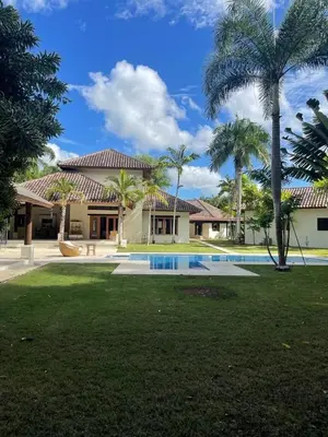 a house with a swimming pool and palm trees at Residence in Juan Dolió, Guavaberry, is ideal in Los Conucos