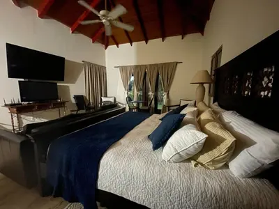 a bedroom with a large bed with a ceiling fan at Residence in Juan Dolió, Guavaberry, is ideal in Los Conucos