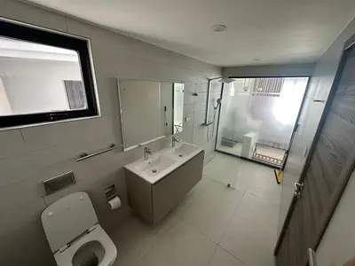 a bathroom with a sink and a toilet and a window at Alexger Beachfront Apartament Bavaro, Punta Cana in Punta Cana