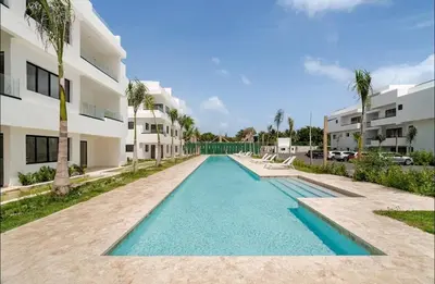 a swimming pool in front of a building at Punta Cana Penthouse Private Picuzzi & Beach Access in Punta Cana