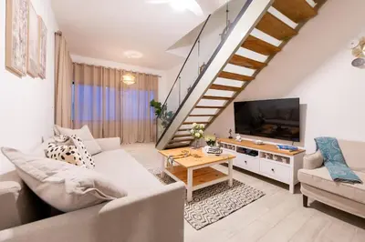 a living room with a couch and a tv at Punta Cana Penthouse Private Picuzzi & Beach Access in Punta Cana